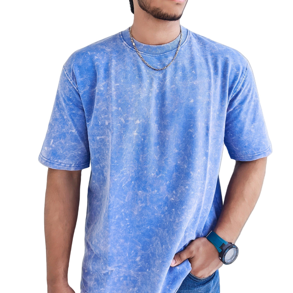 Man wearing a Blue Acid Wash t-shirt in a bright indoor setting