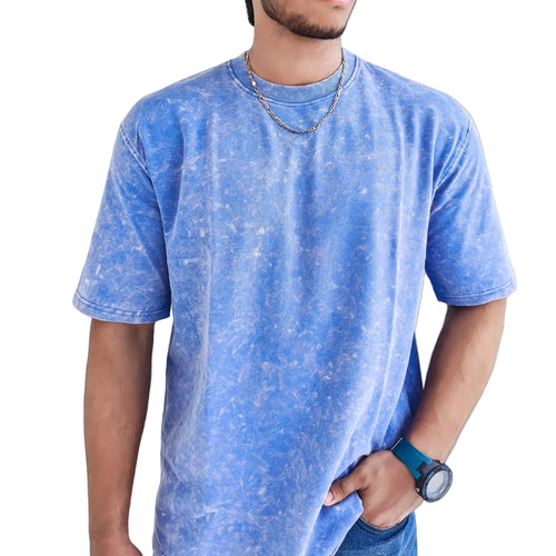 Man wearing a Blue Acid Wash t-shirt in a bright indoor setting